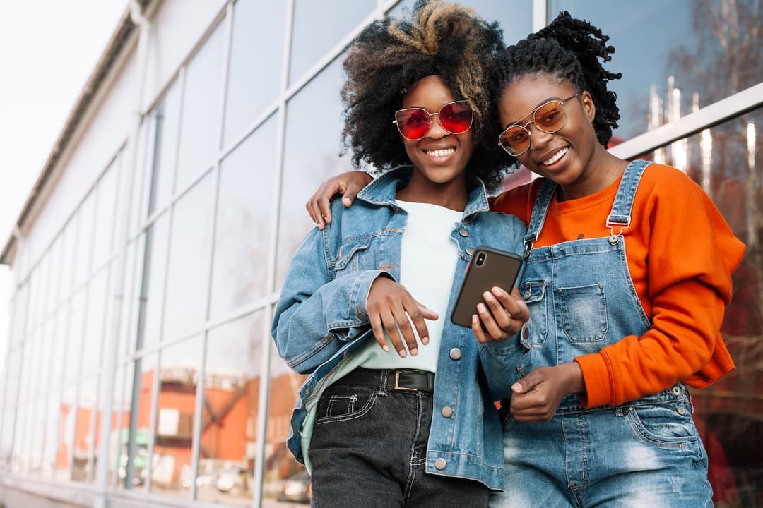 Two young women smiling at a phone